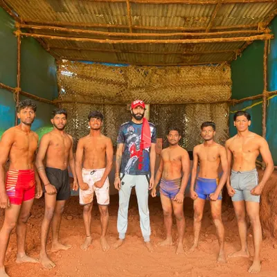 I stand with my students in our Garadi, the traditional mud pit for Kusti. This is where we build fighters from the ground up, connected to our Indian roots.