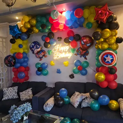 A close-up of our Marvel superhero balloon arch, featuring Captain America and Spider-Man foil balloons, a 'Happy Birthday' neon sign, and a vibrant color scheme.