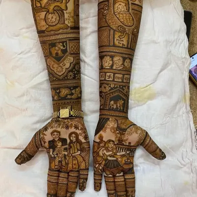 A complete and detailed baby shower mehndi. This design includes a family portrait, a baby in a cradle, and other auspicious symbols to bless the family.