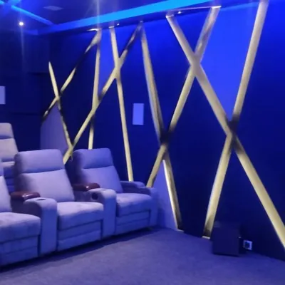 A closer look at a custom acoustic wall featuring a geometric, backlit design. This not only enhances the room's modern aesthetic with vibrant blue light but also helps in managing sound reflections.