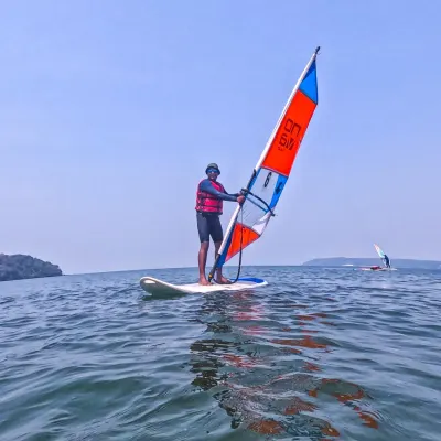 A windsurfer expertly balances on his board, harnessing the power of the wind to glide across the sea in Goa. We provide all the necessary gear and instruction for you to learn this graceful and challenging sport.