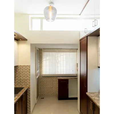 We transformed this kitchen by removing a wall to create a brighter, more open space. The design features a mix of dark wood and white cabinets, a unique brown granite countertop, and a beautiful glass tile backsplash that comes to life in the daylight.