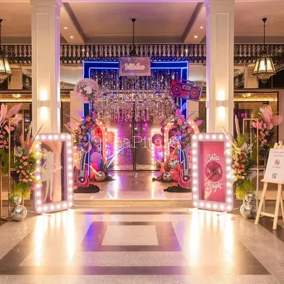 The grand entrance to an 11th birthday disco extravaganza, featuring a shimmering curtain, neon signs, and illuminated frames that set a glamorous and funky tone.