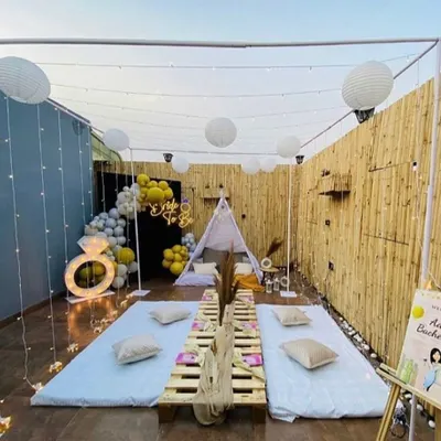 This wide shot showcases a complete boho-chic bachelorette party we designed on a Bengaluru terrace. The decor includes low pallet tables, a cozy teepee for photos, a "Bride to be" neon sign, and a custom welcome sign, all tied together with warm lighting.