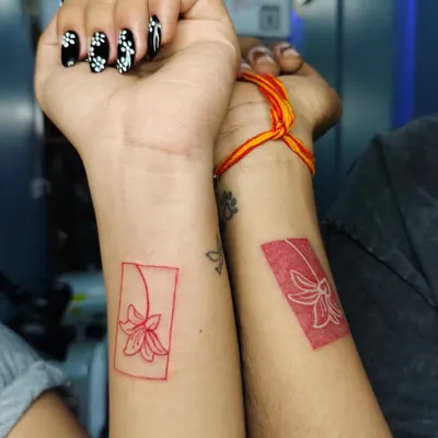 When love is permanent, so is the ink. These matching red ink floral tattoos are a beautiful and artistic way for a couple to show their connection.
