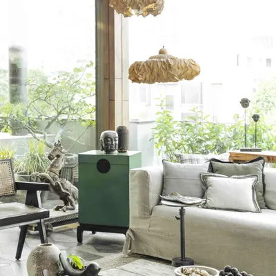 The conservatory, or sunroom, is rooted in a Wabi-Sabi aesthetic, embracing imperfection and natural elements. The space features a rustic coffee table from Nagaland and a striking horse sculpture from Jew Town, Kochi.
