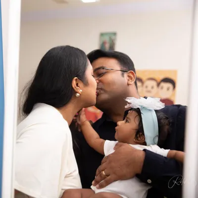A beautiful mirror-reflection shot captures a tender kiss between new parents, while their little one looks on. This in-home session is a perfect example of capturing a family's new dynamic and the love that now includes one more.