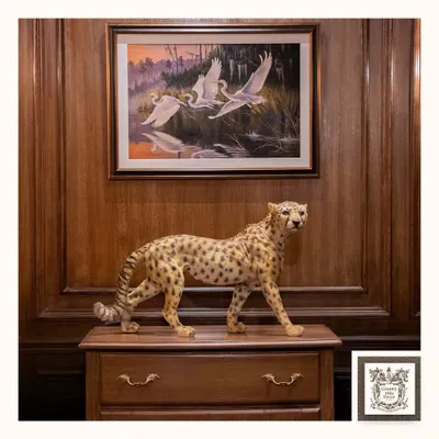 This handcrafted cheetah sculpture, set against a rich wood-paneled wall, is a bold statement of art and elegance. It adds character and a story to your space, blending classic style with a touch of the wild.