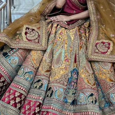 This multi-colored velvet lehenga shows the kind of detailed craftsmanship I offer. The skirt is decorated with elephant and peacock motifs in panels, giving it a very traditional and regal feel for your main wedding day.