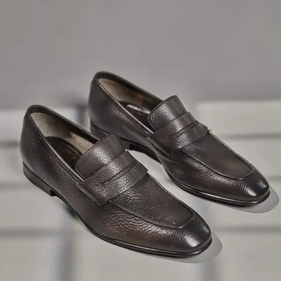 Crafted for the luxury man, these dark brown textured leather loafers are a testament to timeless style and quality. The classic penny loafer design is elevated by the rich, grained leather.