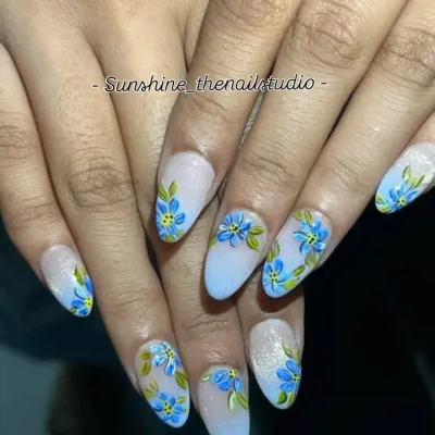 A beautiful example of hand-painted floral art. This spring-themed set features delicate blue flowers on a light blue ombre base with a touch of glitter.