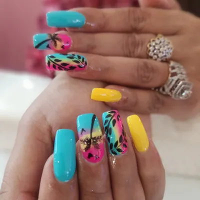This vibrant, hand-painted tropical beach scene on long square extensions shows the level of detail I love to create. It combines a sunset gradient, silhouette palm trees, and leafy patterns for the perfect vacation-ready manicure.