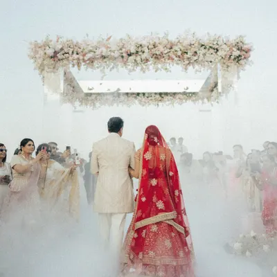 A bride's magical walk towards her forever. We created this dreamy aisle with ethereal smoke, leading to a floating mandap against the sea in Oman, turning a simple walk into a cinematic moment.