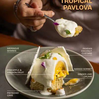 Our Tropical Pavlova is bright, complex, and light as a whisper. It features a pistachio cake base, mango sorbet, pineapple and passion fruit, pandan coconut custard, and crisp meringue shards.