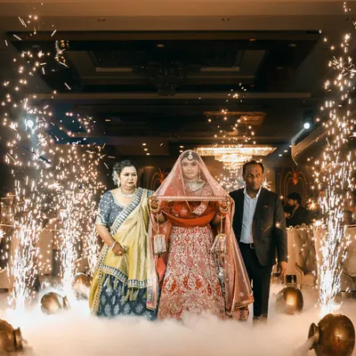 A dramatic bridal entry is a must. I capture the bride walking in with her parents, surrounded by smoke and sparklers, creating a truly filmi and memorable entrance.