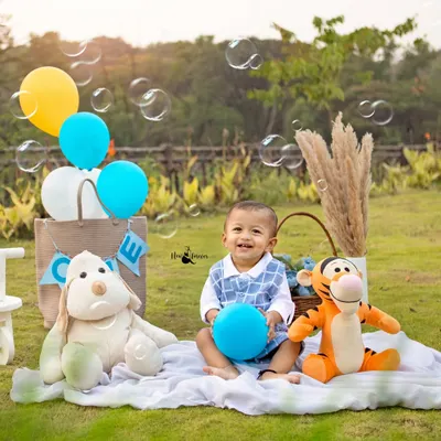 Pure happiness. This little boy's smile is infectious as he plays with bubbles during his outdoor picnic themed first birthday shoot.