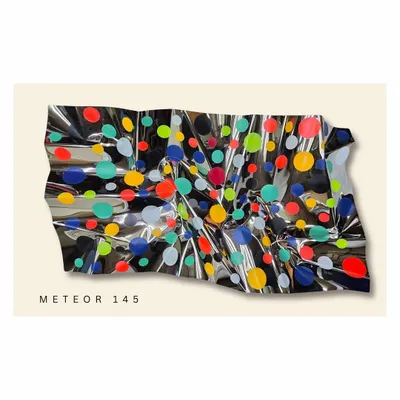 "Meteor 145" is a celebration of joy suspended in time. The colorful polka dots seem to float on the reflective, undulating surface of the stainless steel, creating a playful and energetic wall installation.