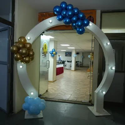 A modern and stylish circular entrance arch with built-in lights. Decorated with blue and gold balloon clusters, it creates an impressive entryway for any birthday party or event.
