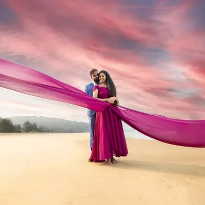 A dramatic beach portrait using a flowing magenta fabric to paint the sky. We love playing with colour and movement to create pre-wedding photos that feel like a work of art.