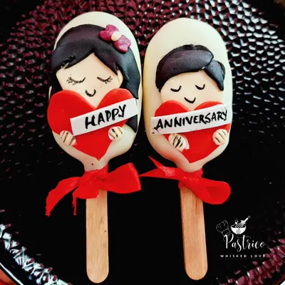 These adorable, customized cakesicles were made for an anniversary. They are filled with dark chocolate cake and decorated with hand-modeled fondant to celebrate the couple.