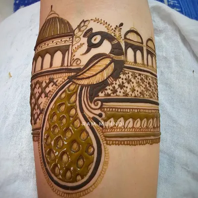 A detailed peacock arm band with a palace dome background. This is a classic and royal design, perfect for bridal or festive wear.