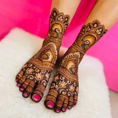 A high-quality, clear shot of beautiful foot mehndi, featuring elegant peacock and lotus motifs that are perfect for a bride.