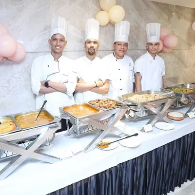 A key part of our full-service offering is coordinating with top-tier caterers. This image shows a professional catering team with a well-organized buffet, demonstrating our commitment to a seamless and high-quality guest experience.