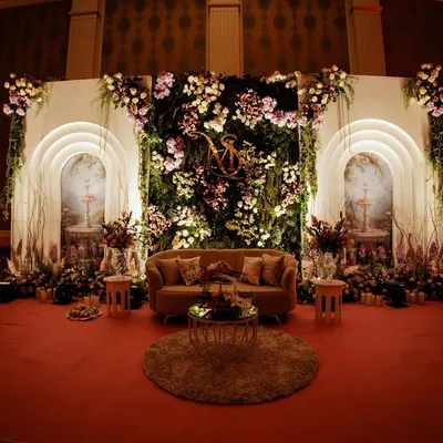 I designed this stage to feel like a secret garden brought indoors. A wall of cascading florals and glowing arches framed the couple's seating, creating an enchanting and romantic backdrop for their ring ceremony.