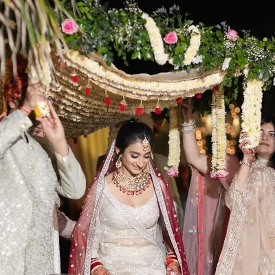 The beautiful bridal entry. Surrounded by her brothers and sisters under a floral phoolon ki chadar, the bride walks towards her new beginning with a gentle smile.