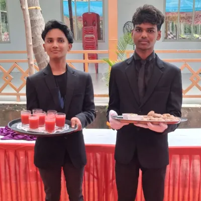 My young and energetic staff members serving welcome drinks and starters at a wedding in Pen. They are dressed in a clean, professional uniform.