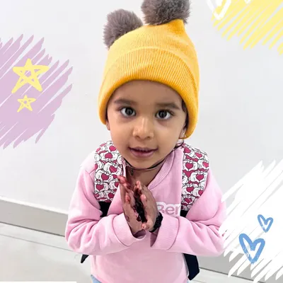 Every child is a star in our story. This little one, with her warm hat and welcoming gesture, embodies the sweet and gentle nature of our school community.