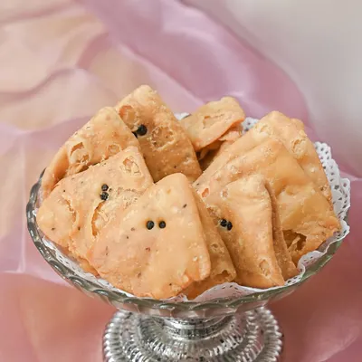 I am passionate about keeping traditions alive. This is a bowl of my golden, crispy mathis, a classic savory snack that is an essential part of my traditional wedding bhaji packs.