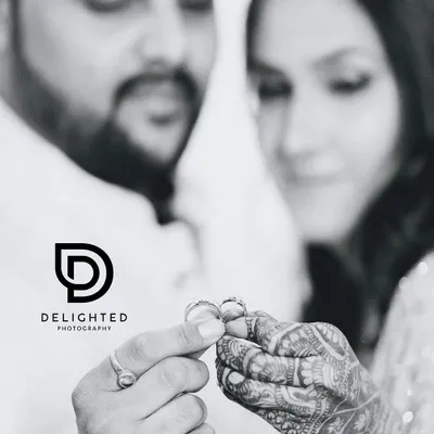 A symbolic black and white shot focusing on the couple's hands as they hold their wedding rings, representing their new commitment and union.