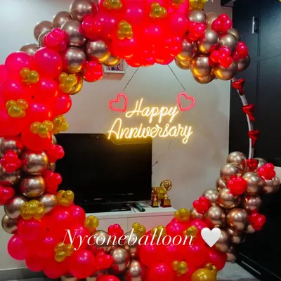For a modern and stylish celebration, I create these circular balloon backdrops. This one uses a vibrant mix of pink and gold balloons and features a bright 'Happy Anniversary' neon sign, perfect for taking memorable photos.