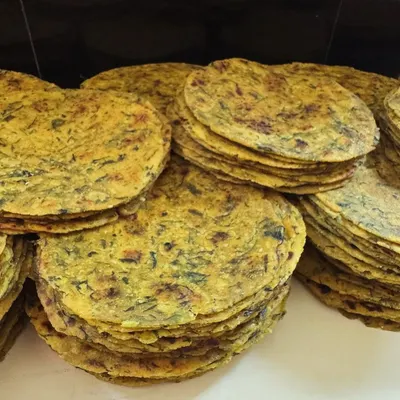 Stacks of freshly made Methi Theplas ready to be packed. These savory fenugreek flatbreads are a travel essential and a wholesome snack for any time of day.