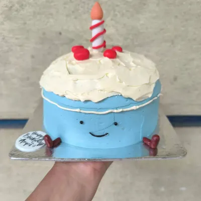 What a cutie. This adorable bento cake is designed to look like a smiling cartoon cake itself, complete with a little candle on top.