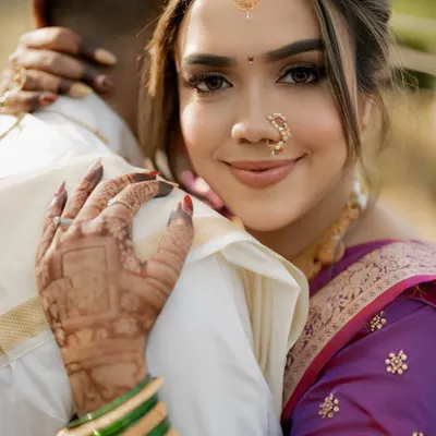 A close-up of our stunning Marathi bride. The look features subtle makeup, the traditional crescent bindi, a classic nath, and other accessories that celebrate her Maharashtrian heritage.