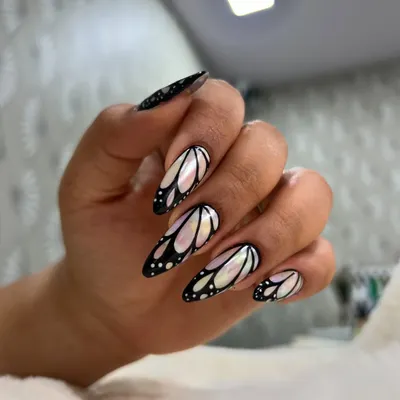 A full hand view of the popular butterfly wing nails. The almond shape complements the design, creating an elegant and elongated look.