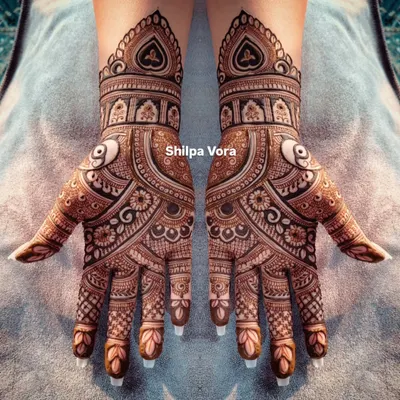 A perfectly symmetrical bridal design with heavy, detailed work covering the entire hand. The use of negative space makes the patterns pop.