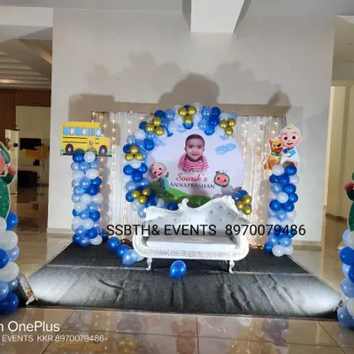 A fun Cocomelon theme for an Annaprasan ceremony. This setup includes a custom backdrop with the baby's photo, character cutouts on balloon pillars, and a small white throne for the main event.