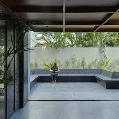 The entrance courtyard for the Rinac HQ, featuring a built-in seating area made of black granite. This outdoor space was designed as a calm and welcoming transition zone for employees and visitors.