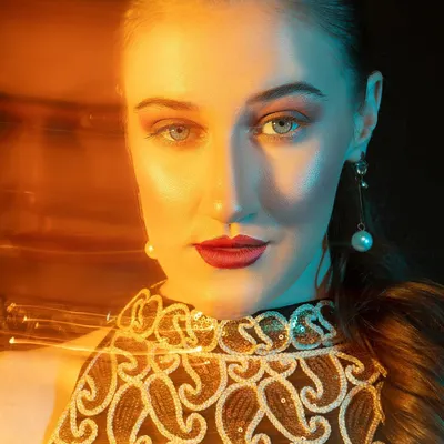 A striking portrait using a mix of warm and cool colored light gels. This technique creates a dramatic, high-fashion look and makes the model's features pop.