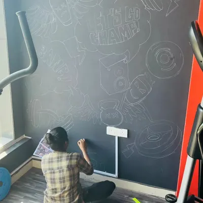 The first step of the gym mural is sketching the entire design with chalk. This allows me to map out the composition directly on the wall and ensure all the elements fit together perfectly before any paint is applied.