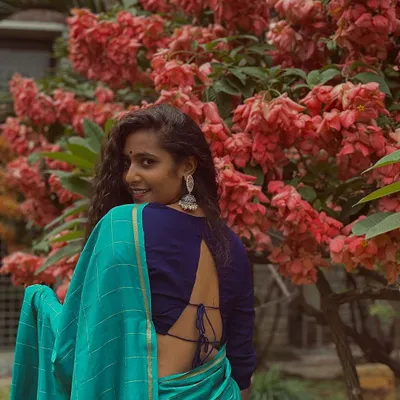Feeling beautiful in this blue saree against a backdrop of lovely flowers.