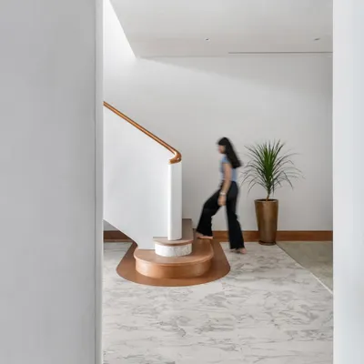 The winding staircase is the defining element of the Worli Duplex, its sculptural form anchoring the home's circulation. We designed its gentle curve to break the apartment's orthogonal geometry, creating a sense of fluid movement between the two levels.
