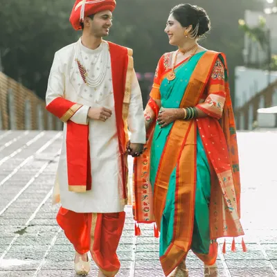 A stunning portrait of a couple in full traditional Maharashtrian wedding attire. The vibrant colors of the nauvari saree and the groom's pheta make for a powerful and culturally rich image.