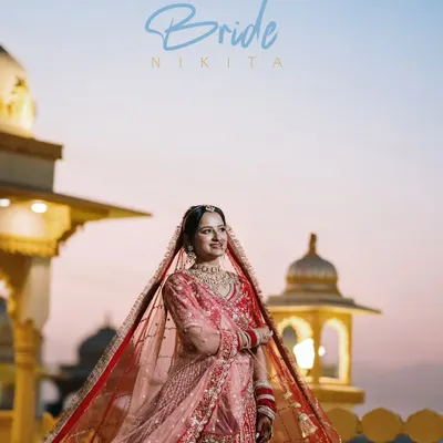A beautiful bridal portrait of Nikita, captured during the golden hour against the backdrop of a palace, her lehenga glowing in the soft light.