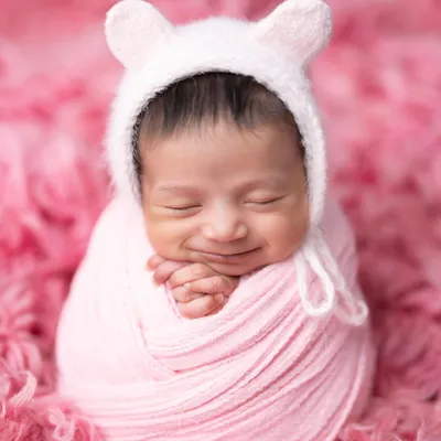 The sweetest smile on this little one, wrapped snugly in pink. I use high-quality, soft fabrics to ensure your baby is comfortable and content throughout the session.