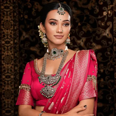This oxidized silver set makes a bold statement against a vibrant pink saree. The intricate design and dark finish create a beautiful contrast, perfect for a contemporary ethnic look.