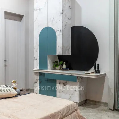 This kid's room combines playful design with practical features. The wardrobe unit includes a built-in desk and a unique circular blackboard for doodling, all finished in a chic white marble and pastel blue.